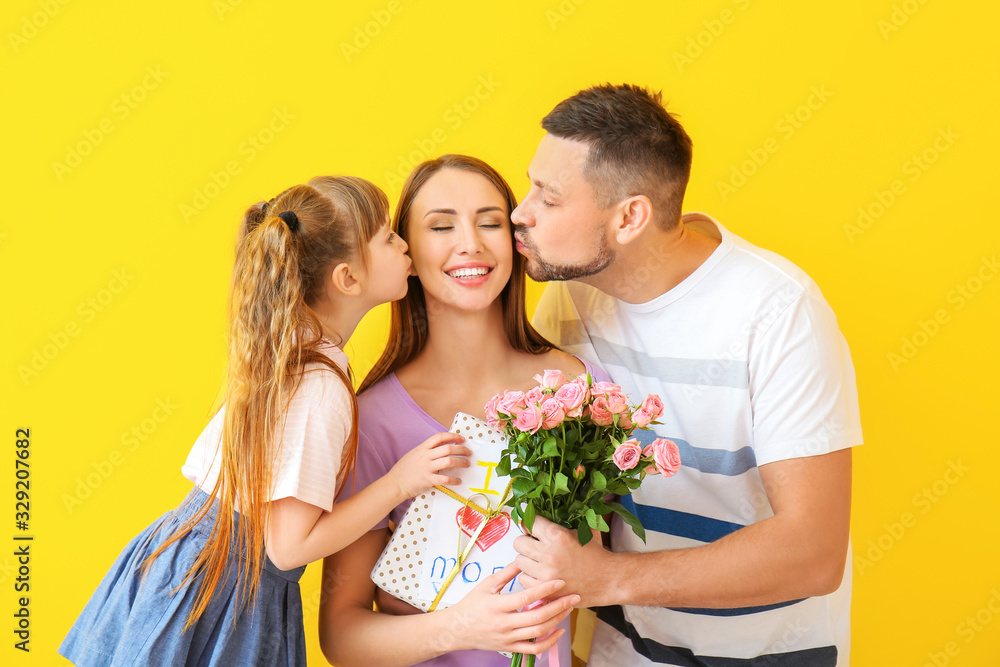 Husband and little daughter greeting woman to Mother's Day on color background Husband and little daughter greeting woman to Mother's Day on color background