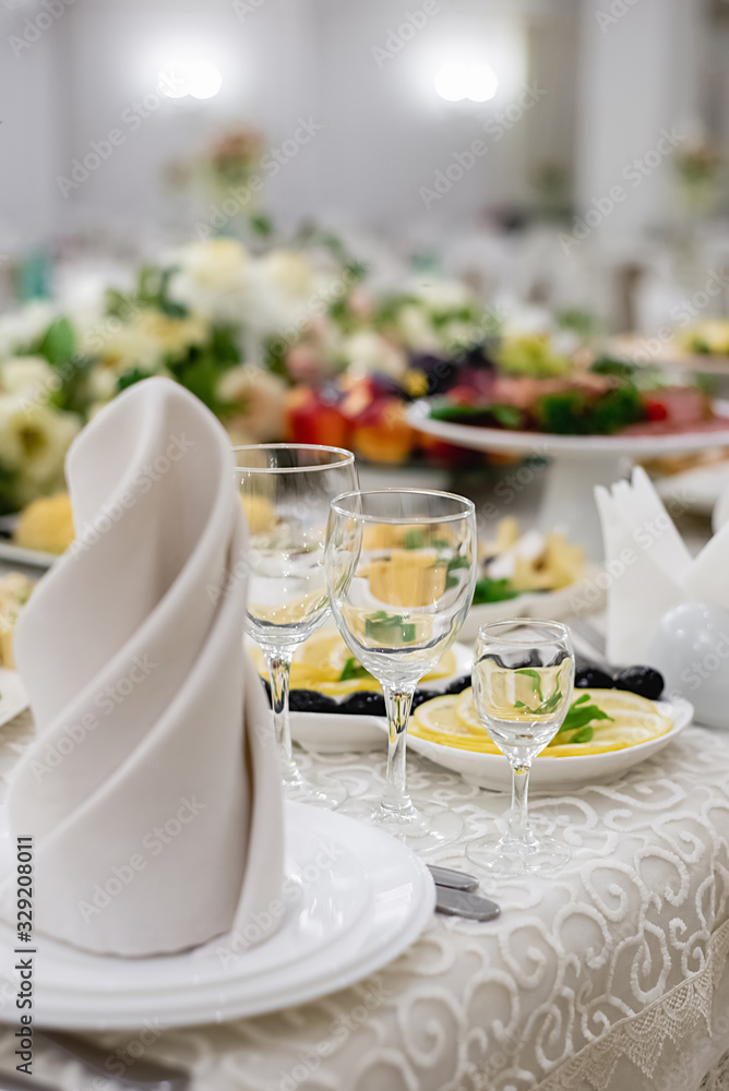 Vertical images of elegant dinner table setting in restaurant or hotel with wine glasses. Luxurious elegant dinner at the table. Holiday table decoration Vertical images of elegant dinner table setting in restaurant or hotel with wine glasses. Luxurious elegant dinner at the table. Holiday table decoration