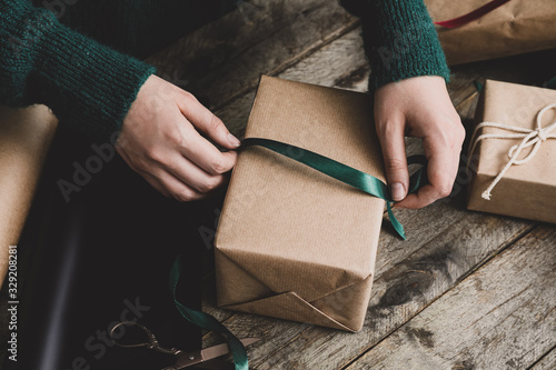 Woman making beautiful Christmas gift at table photo