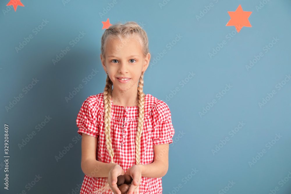 Cute little girl with sweet chocolate eggs on color background Cute little girl with sweet chocolate eggs on color background