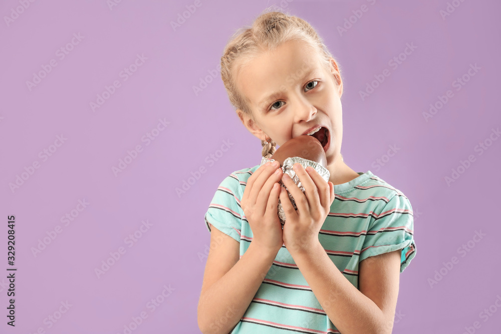 Cute little girl with sweet chocolate egg on color background Cute little girl with sweet chocolate egg on color background