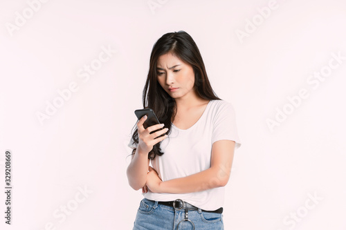 Happy Asian businesswoman using mobile phone isolated over white background. Girl holding the smartphone in a summer t-shirt Short jeans. Copy space