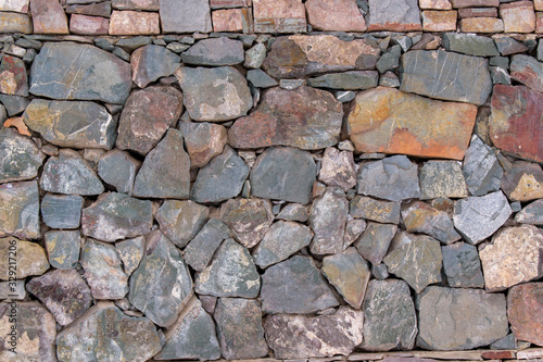Stone wall for the backdrop. Sharp blocks of color with shades of gray and brown. Concept of old antique masonry.