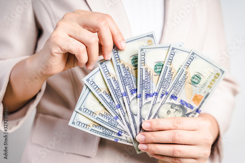 Closeup of business woman hands counting money us dollar bills on white background. Money Concept.