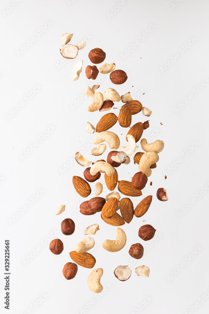 Flying nuts on a grey background: almonds, cashew and hazelnat - obrazy, fototapety, plakaty 
