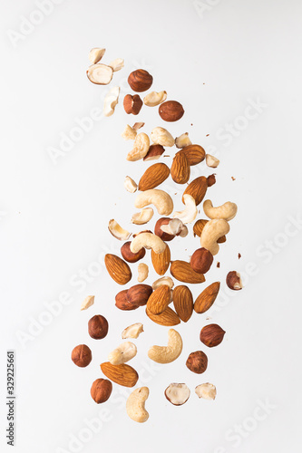 Flying nuts on a grey background: almonds, cashew and hazelnat