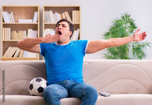 Man watching football at home sitting in couch