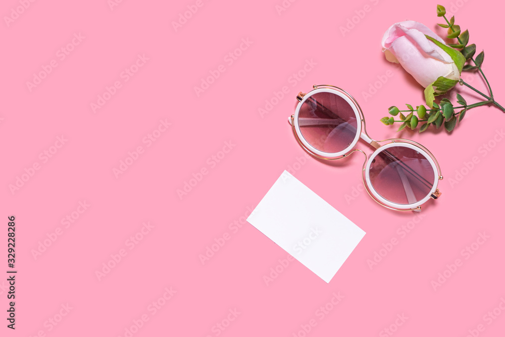 A layout of a sun glass, blank paper note, and white pink roses laying on pink background, representing decoration of copy space of gifts for Christmas, valentine’s day, birthday and special events - obrazy, fototapety, plakaty 