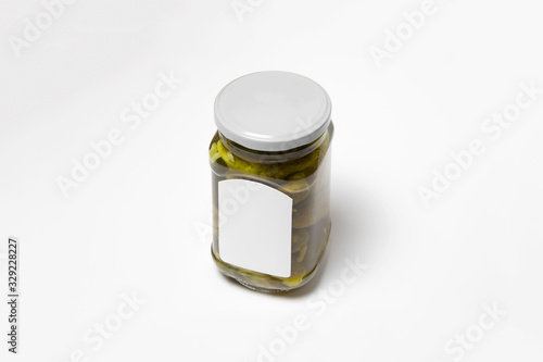 Glass jar with Pickled Cucumbers on white background with blank label.Marinated cucumbers in mason jar.High resolution photo.