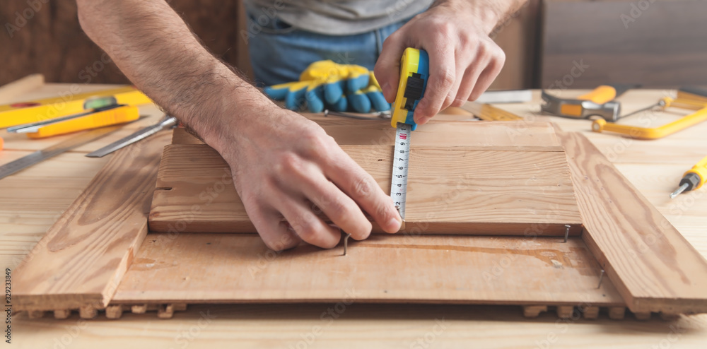 Carpenter with ruler measuring wood plank. Carpenter with ruler measuring wood plank.
