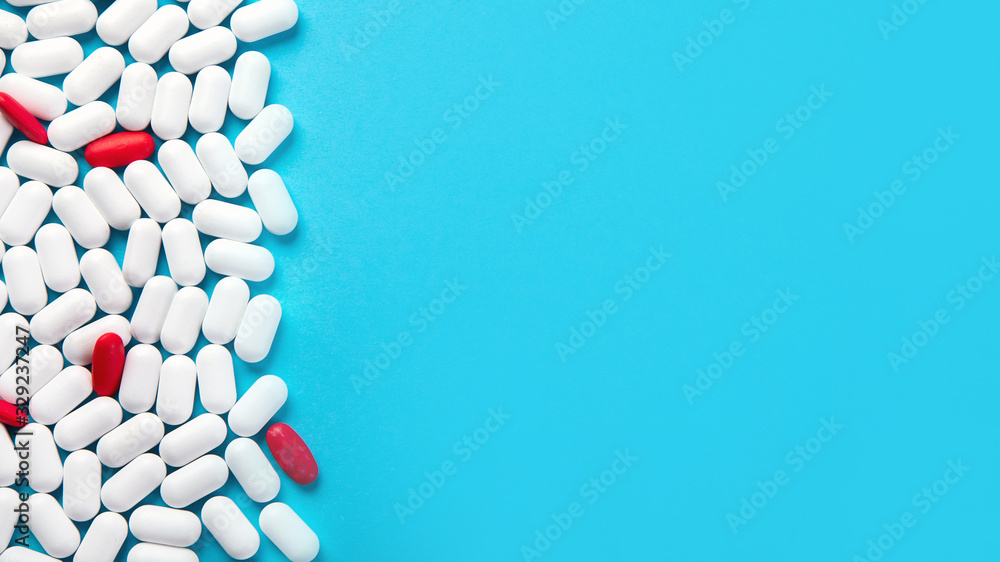 Obraz premium Sterta pigułek na niebieskim tle