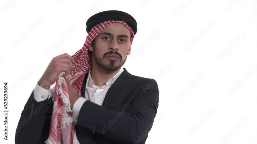 Close-up demonstration video of Arab man wearing and fitting traditional male eastern headdress kufiya. Isolated, on white background Close-up demonstration video of Arab man wearing and fitting traditional male eastern headdress kufiya. Isolated, on white background