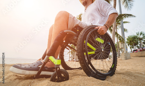 Disabled man in a wheelchair on the beach.