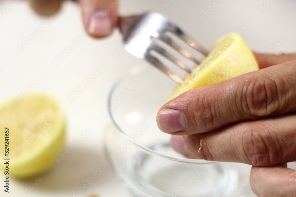 Juice lemon half with assistance of fork. Making Lemon Mascarpone Pie Series. Juice lemon half with assistance of fork. Making Lemon Mascarpone Pie Series.
