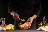 Cooking seafood shrimp with vegetables, on a black background the chef cooks. Asian and Thai cuisine. Freeze motion