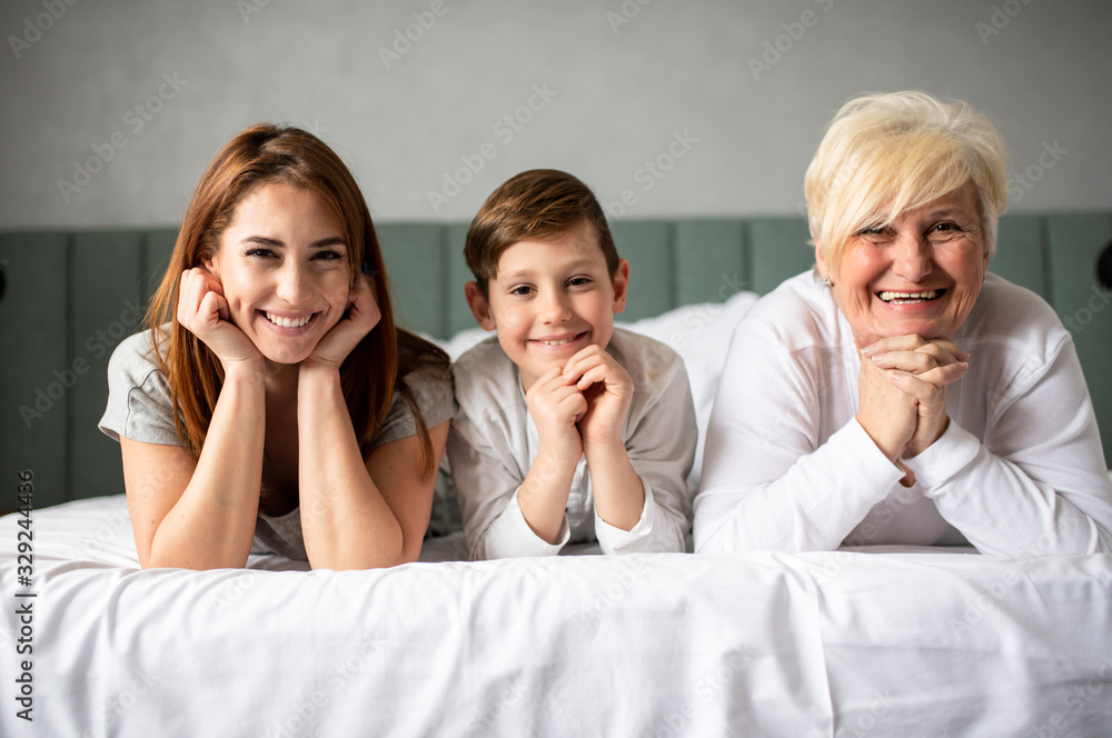 A happy and beautiful family posing for the picture, on the bed whilst smiling. A happy and beautiful family posing for the picture, on the bed whilst smiling.