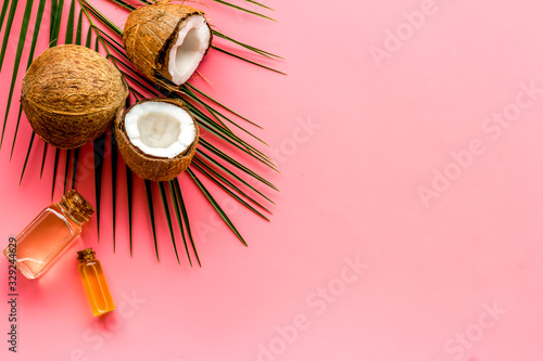 Coconut background with oil on pink background top-down copy space