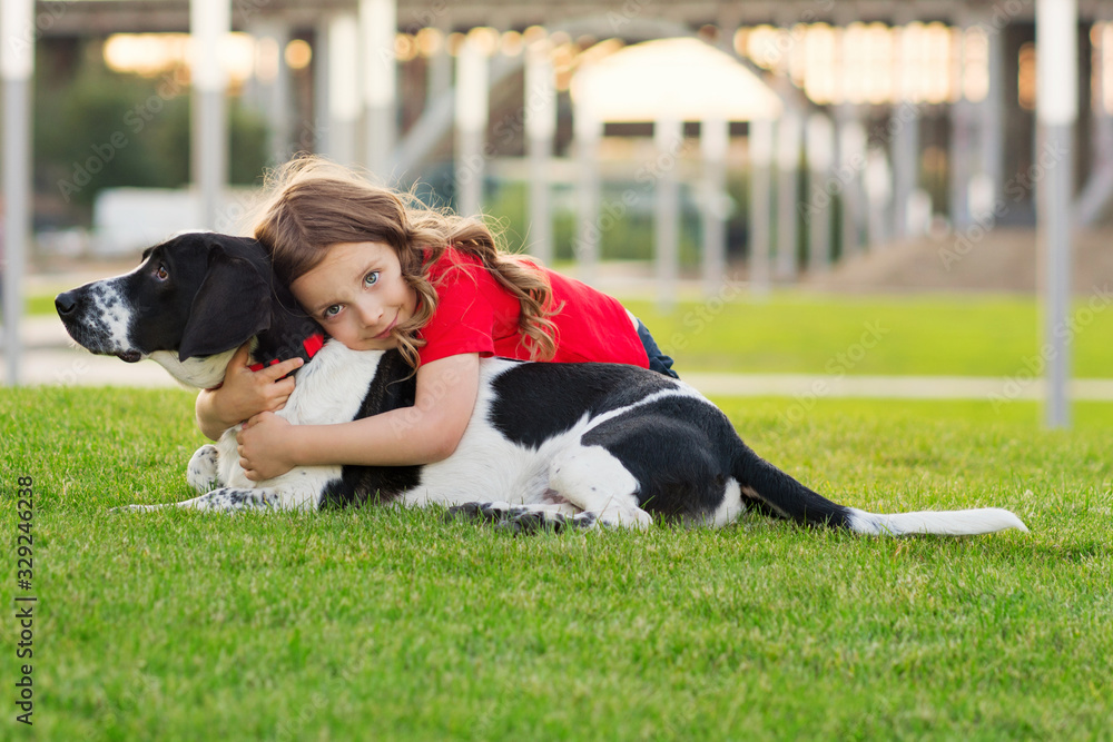 Beautiful young girl is hugging her pet. Cute photo of dog and its owner relaxing on the grass. Faithful friends of human. Concepts of friendship, leasure, pate care, togetherness. Domestic animal. Stock Beautiful young girl is hugging her pet. Cute photo of dog and its owner relaxing on the grass. Faithful friends of human. Concepts of friendship, leasure, pate care, togetherness. Domestic animal. Stock