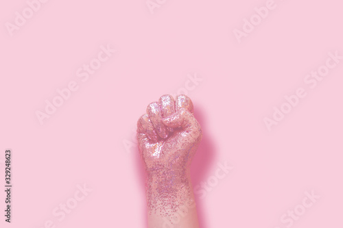Foto woman fist covered in pink glitter on pink background