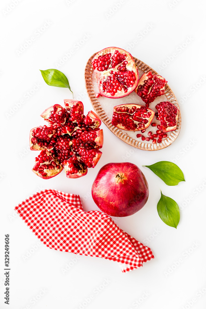 Cut pomegranate with ripe seeds on white background top-down Cut pomegranate with ripe seeds on white background top-down