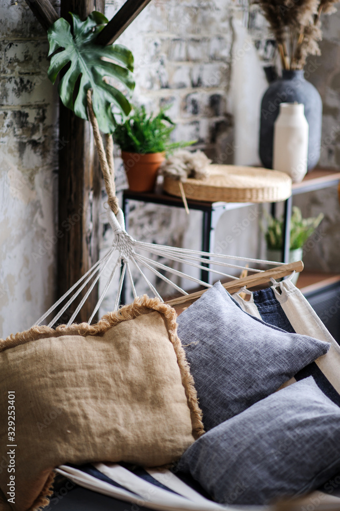 Pillows lie in a hammock against a brick wall Pillows lie in a hammock against a brick wall