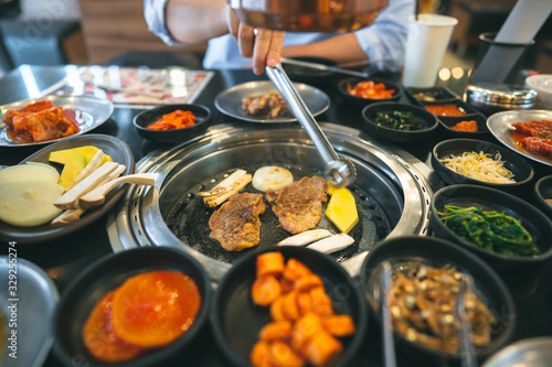 Photography Korea bbq style restaurant  with meat and vegetable side diesh.