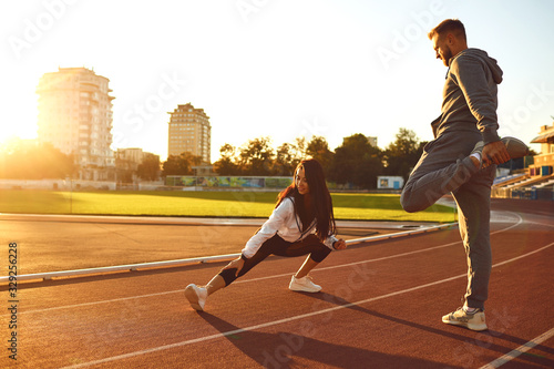 Couple in sportswear doing warm-up at the stadium