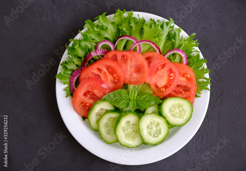 Cuadro en lienzo Healthy fresh vegetarian salad on a dish on black background