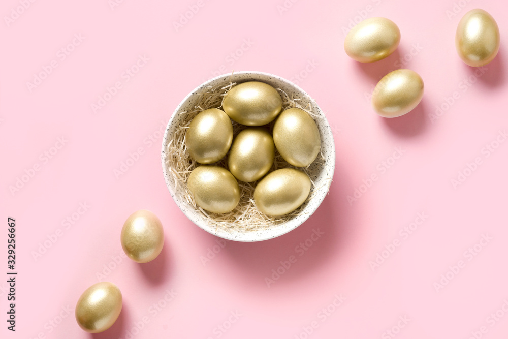Easter golden chicken eggs in bowl on pink. View from above. Minimal composition.