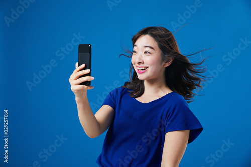 スマートフォンを持って驚く女性 photo