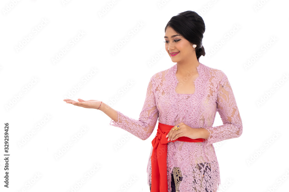 Young Balinese woman wearing traditional clothes with presenting a product Young Balinese woman wearing traditional clothes with presenting a product