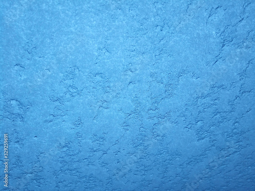 Texture of snow-white snowflakes on the surface. Beautiful frosty snow pattern on the window. Winter Wallpaper with frosty snowflakes on the glass