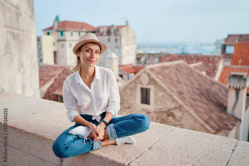 Traveling by Croatia. Young traveling woman enjoying old town Split view, red tiled roofs and ancient architecture.
