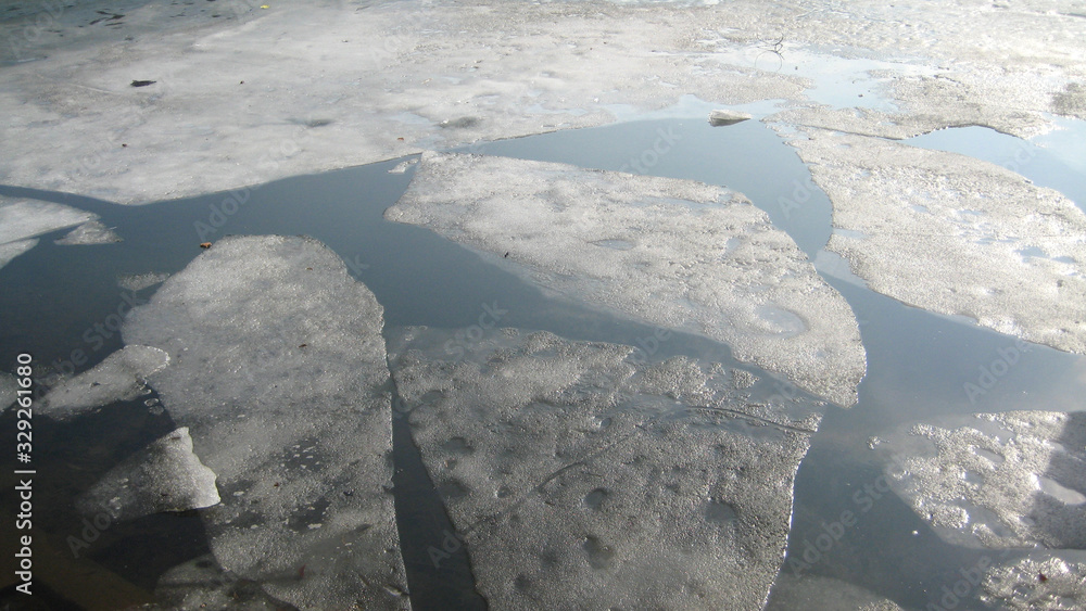 A photo of ice melting in a dark river. 
