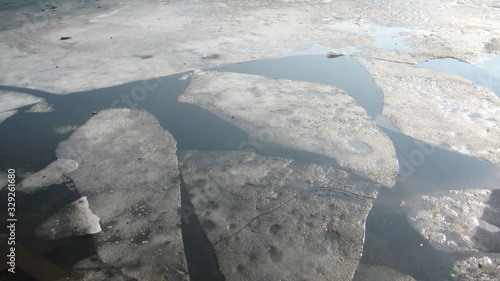 A photo of ice melting in a dark river. 