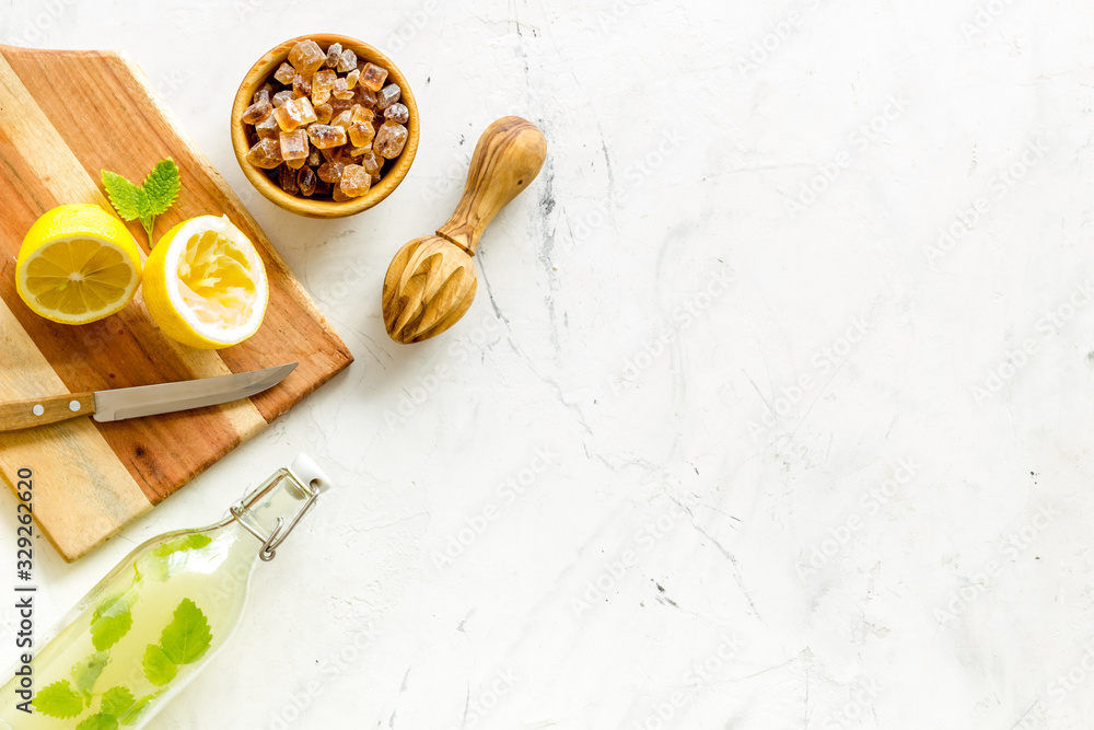 Make lemonade. Drink in bottle near utensil on white background top-down copy space Make lemonade. Drink in bottle near utensil on white background top-down copy space