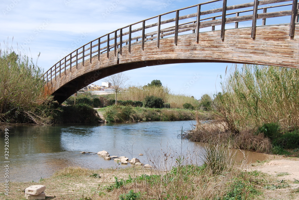 Fototapeta premium Curved Wooden Bridge over River Turia, Spain