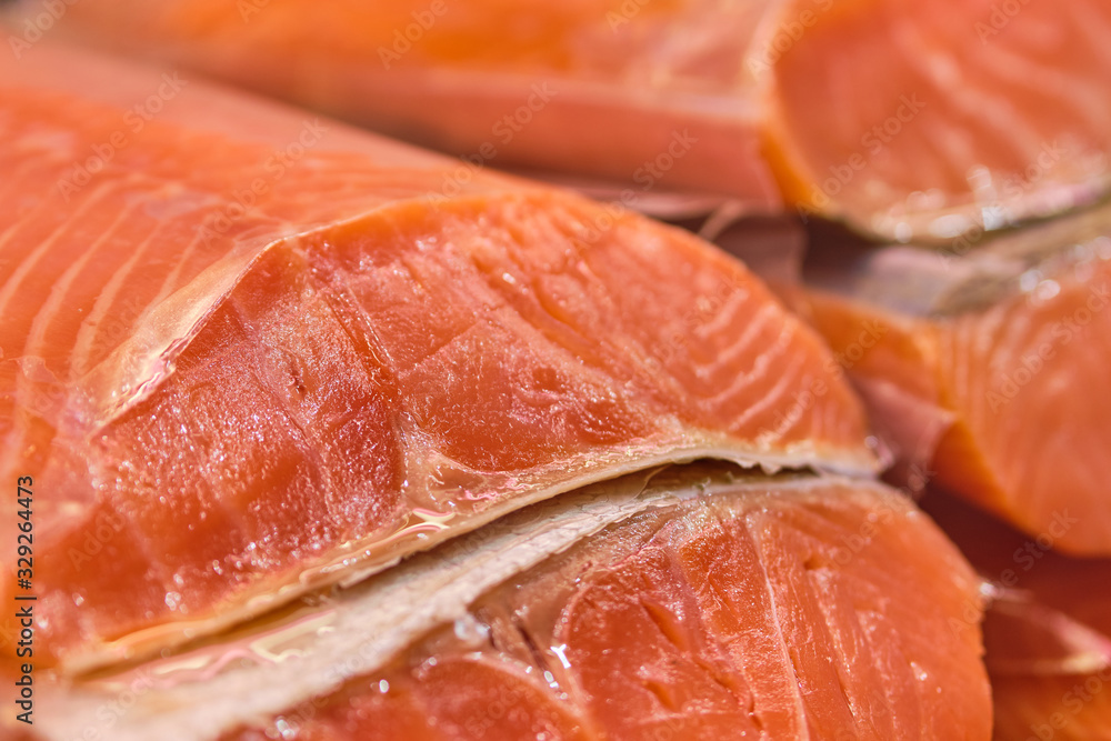 Smoked red fish in a section on a store counter.