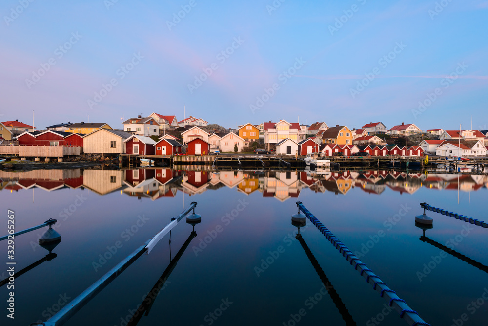 Colourful houses reflected in a still harbour, Sweden.