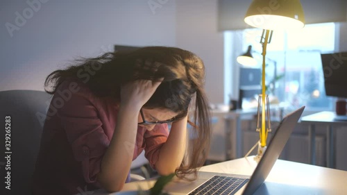 Worried business woman face looking at laptop in office. Close up of upset businesswoman thinking about mistakes in work. Portrait of sad girl looking laptop. Depressed employee working on laptop