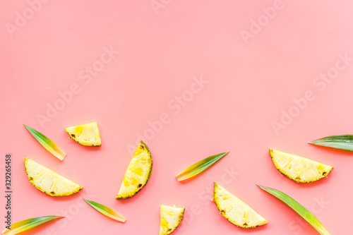Pineapple slices on pink background top-down frame copy space
