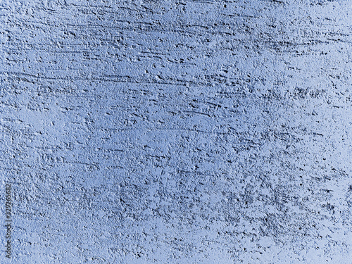 Blue stucco on the scratched wall surface. Painted putty. Decorative construction materials and colours. Abstract background texture pattern with copyspace