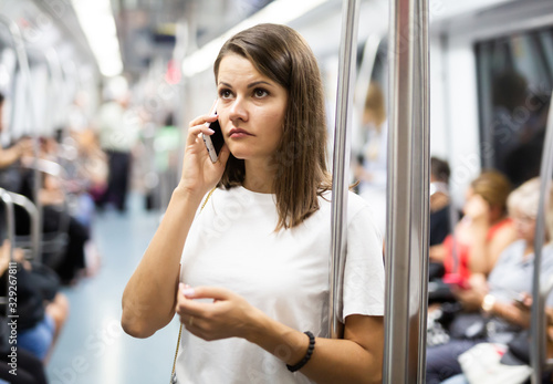 Female talking on smartphone in subway car