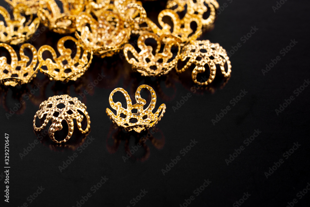 Metal jewelry accessories are scattered on a black background Metal jewelry accessories are scattered on a black background