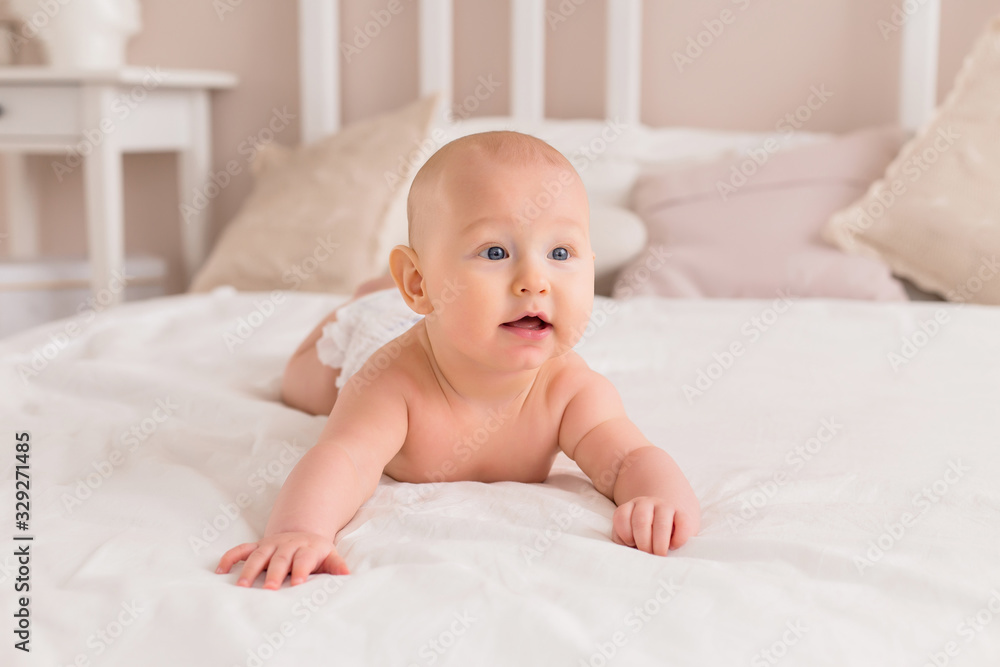 baby boy smiling and lying on a light bed at home baby boy smiling and lying on a light bed at home