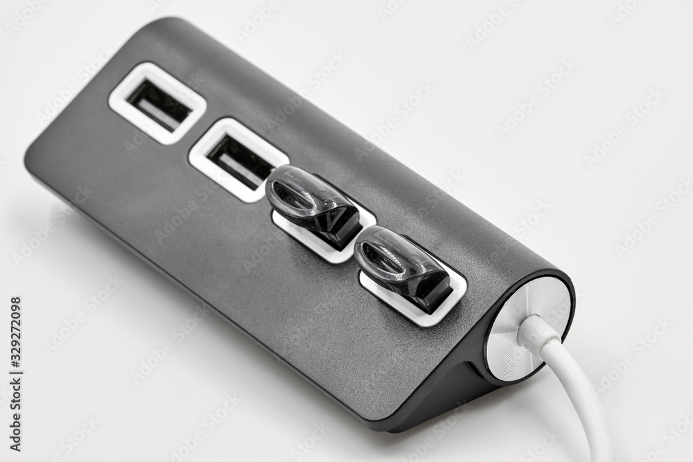 Black portable USB hub for four connections with usb flash drives on a white background. Bus povered. Closeup, selective focus Black portable USB hub for four connections with usb flash drives on a white background. Bus povered. Closeup, selective focus