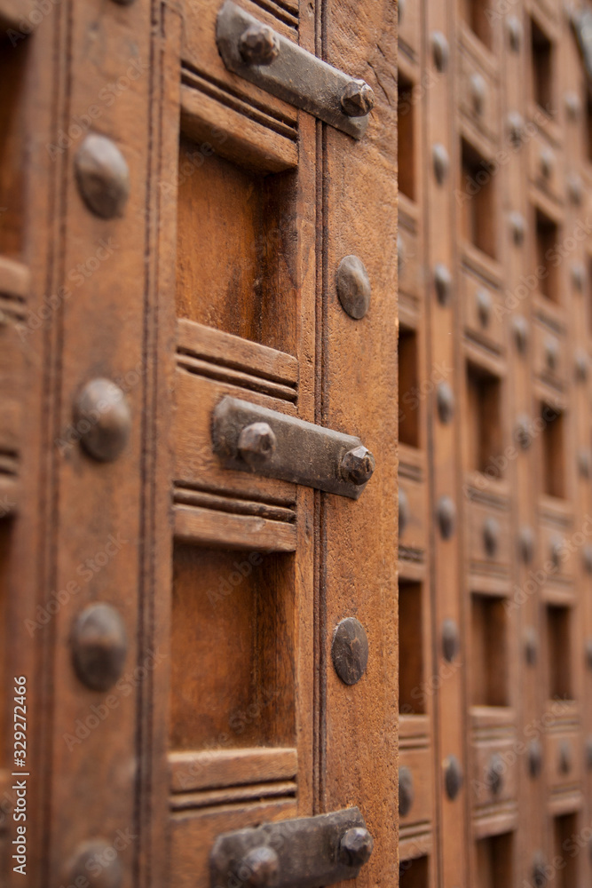 Fototapeta premium Large ornate wooden doors with metal latch and studs