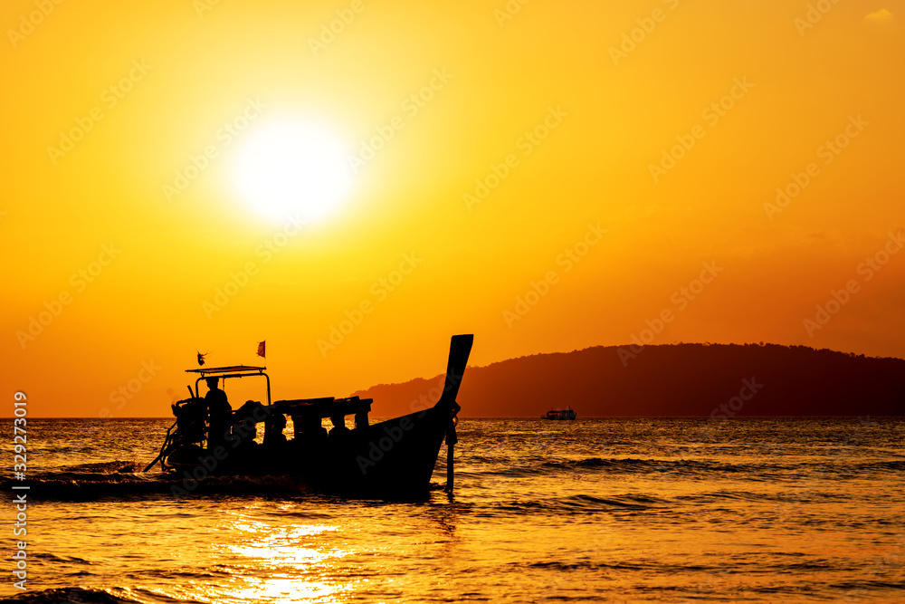 Traditional long-tail boat on the beach at sunset in Thailand Traditional long-tail boat on the beach at sunset in Thailand