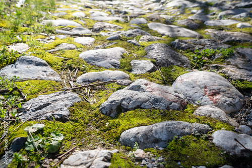 Ancient footpath from block stones from medieval age, texture stones, background of old stones. Old pavement.