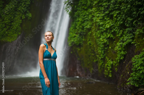 beautiful girl walks near a waterfall